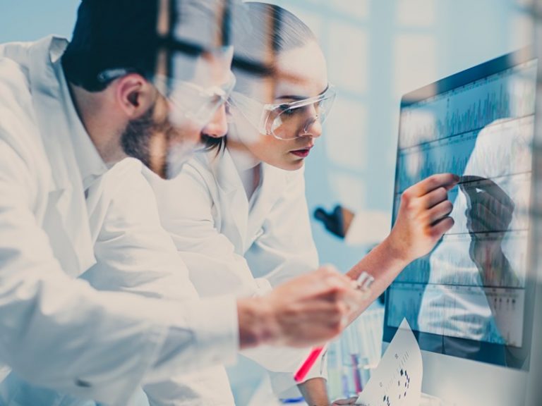 Scientists looking at a DNA sequence on the monitor